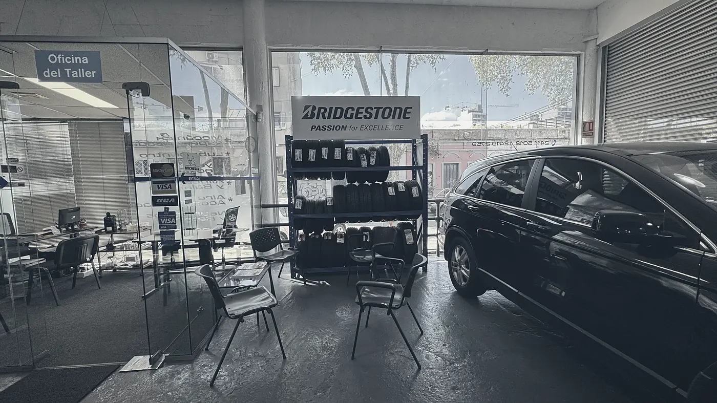 Recepción del taller con la oficina, la sala de espera y un auto